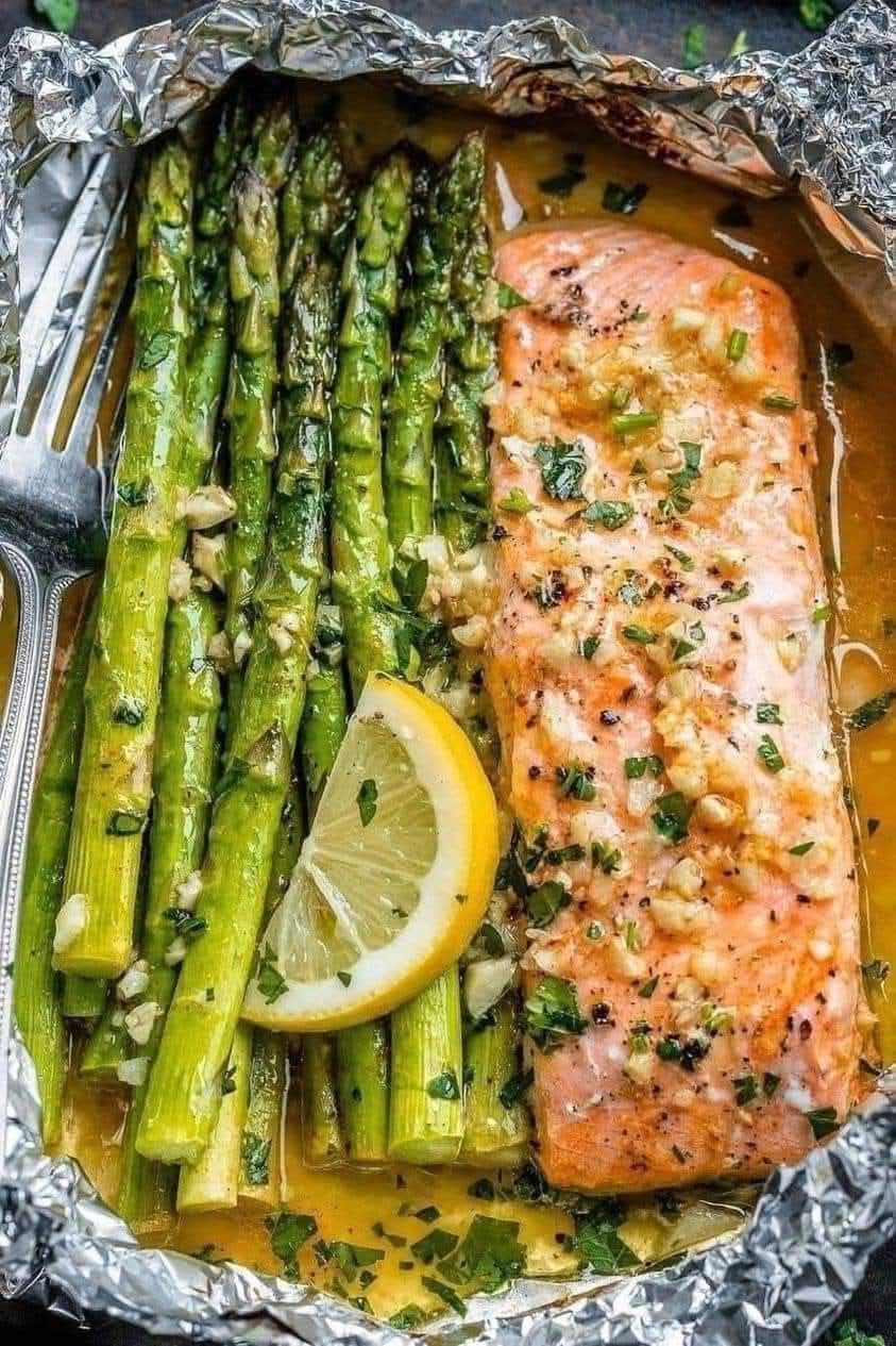 Baked salmon in foil with asparagus and lemon garlic butter sauce